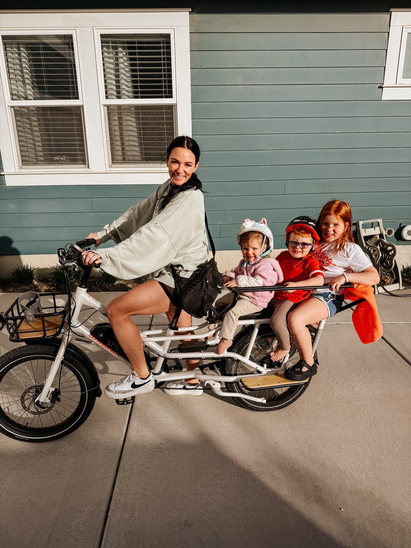 Nikki on a cargo bike in the driveway