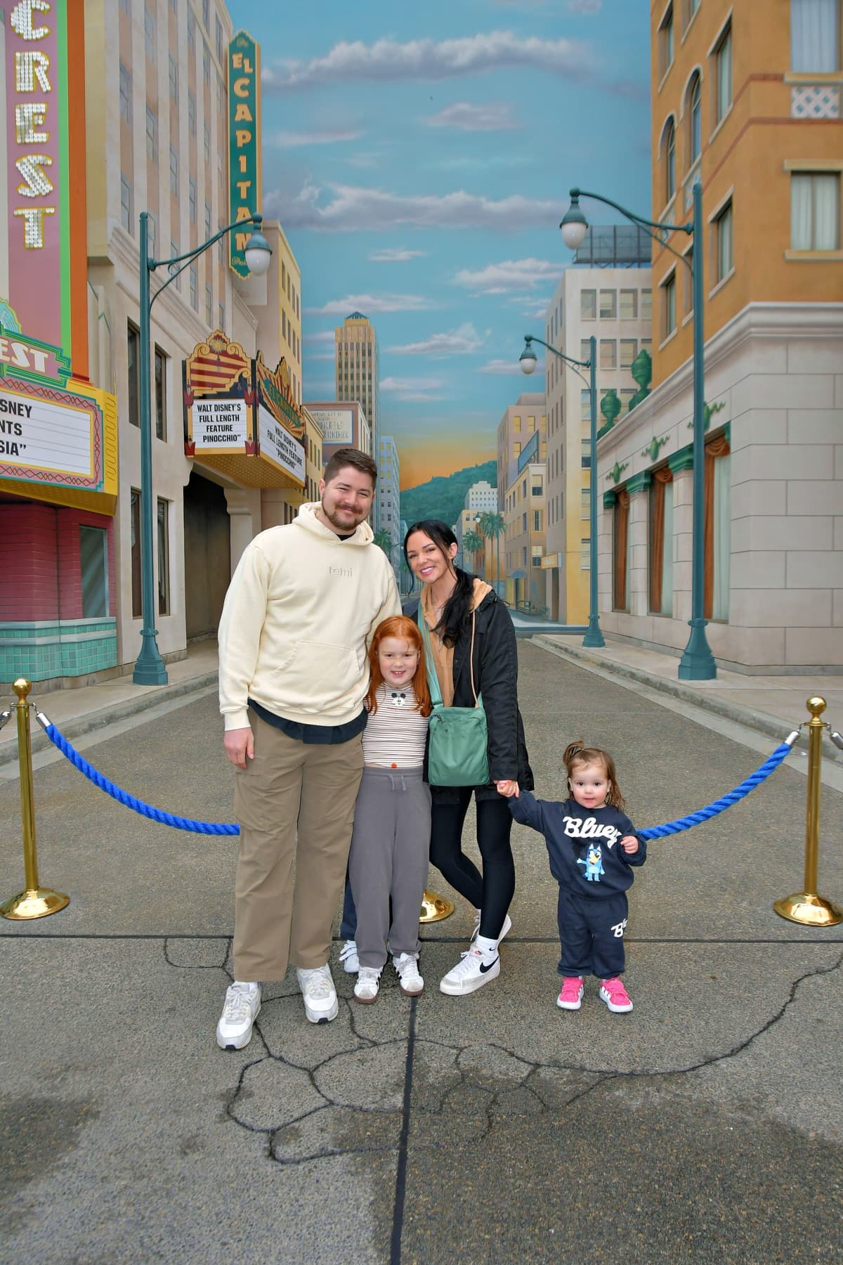 Family standing together in front of a painted street mural